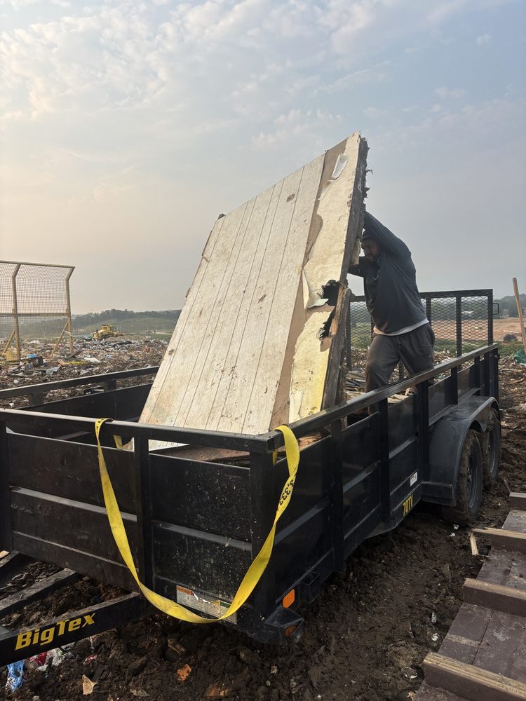 Happy Movers loading debris onto a hauling trailer